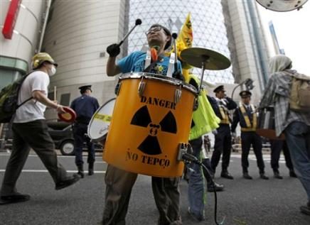 a-protester-beats-a-drum-in-front-of-a-showroom-of-tokyo-electric-power-co-tepco