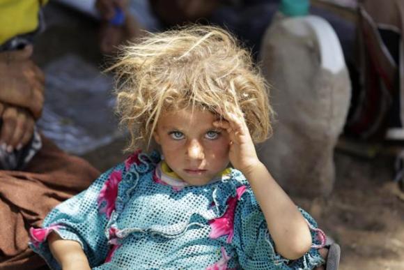 Una niña de la etnia minoritaria yazidi, oriunda de la población iraquí de Sinjar y que huye de la persecución de combatientes del Estado Islámico, es fotografiada en el cruce fronterizo entre Irak y Siria, en Fish